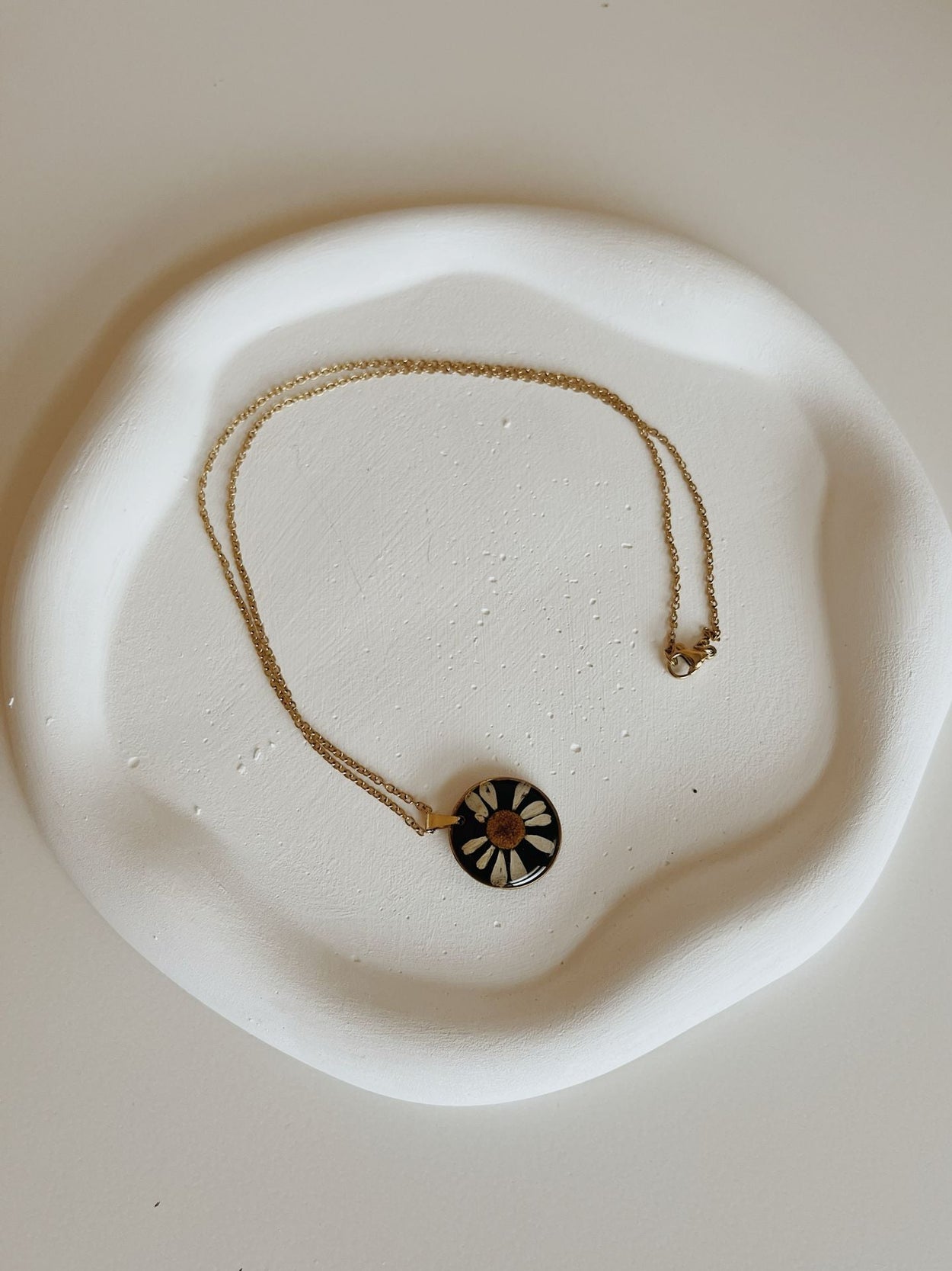 Necklace with a decorative pendant on a white dish