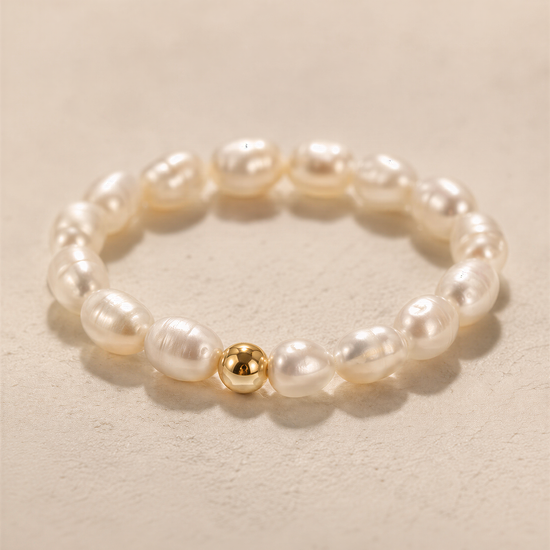 A bracelet made of white pearls and a single gold-colored pearl.