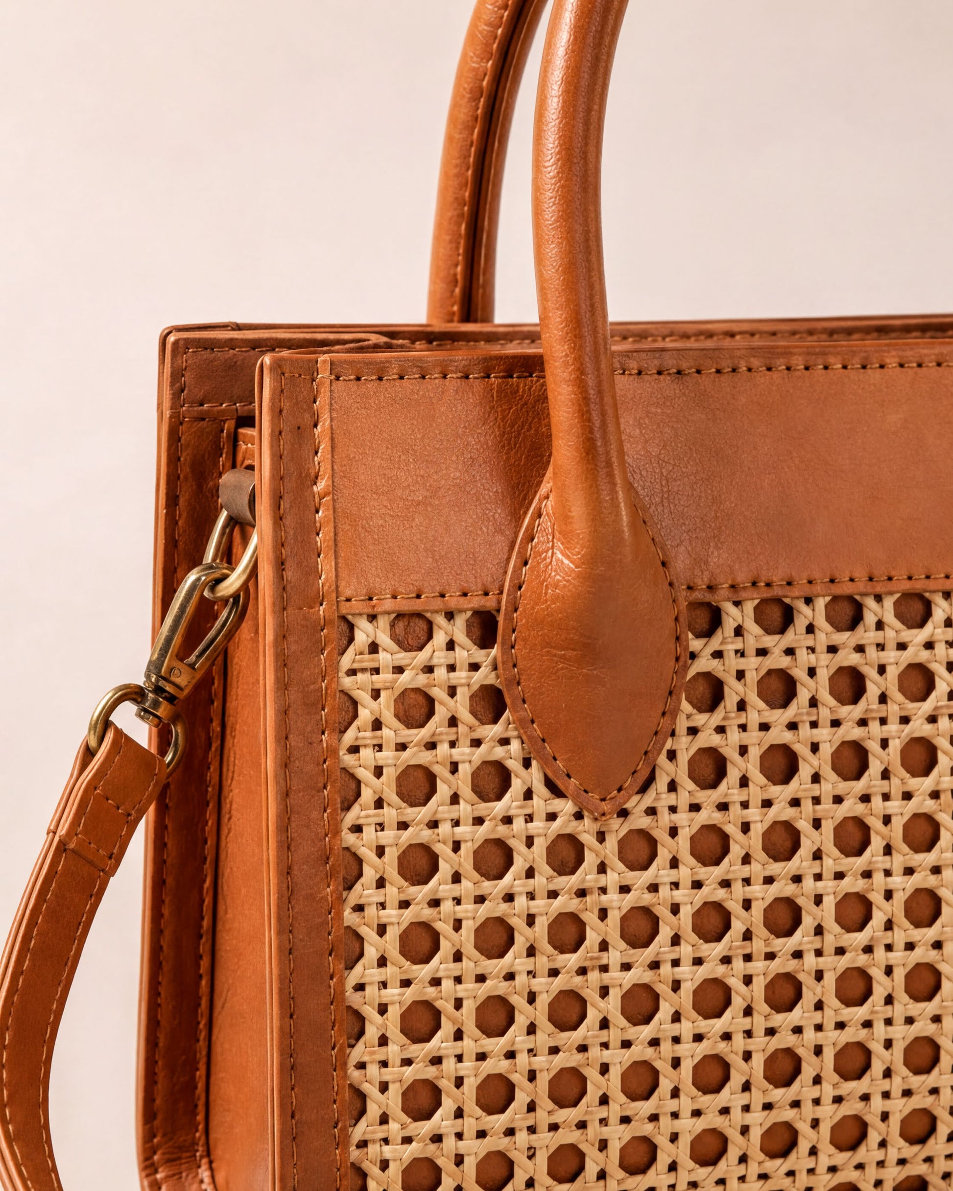 A brown leather handbag with a woven pattern on the front.