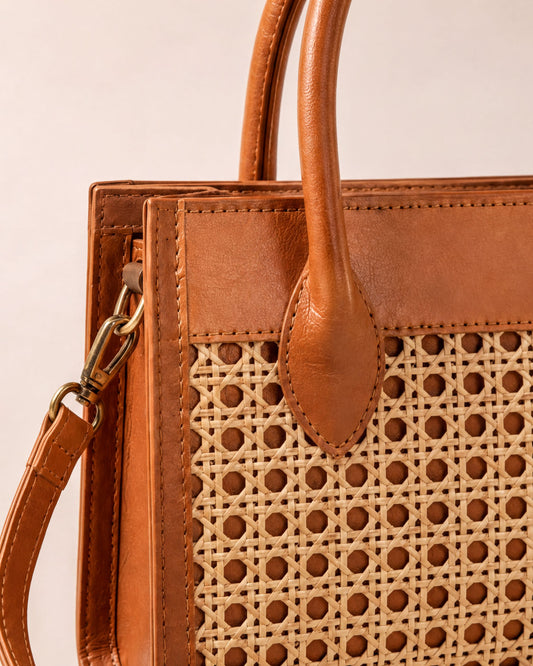 A brown leather handbag with a woven pattern on the front.