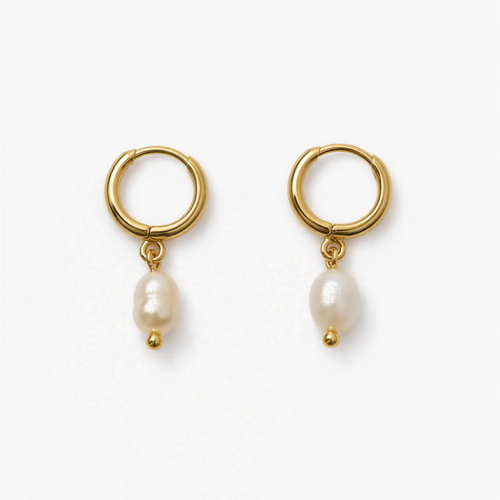 A pair of gold earrings with a pearl hanging from each earring.