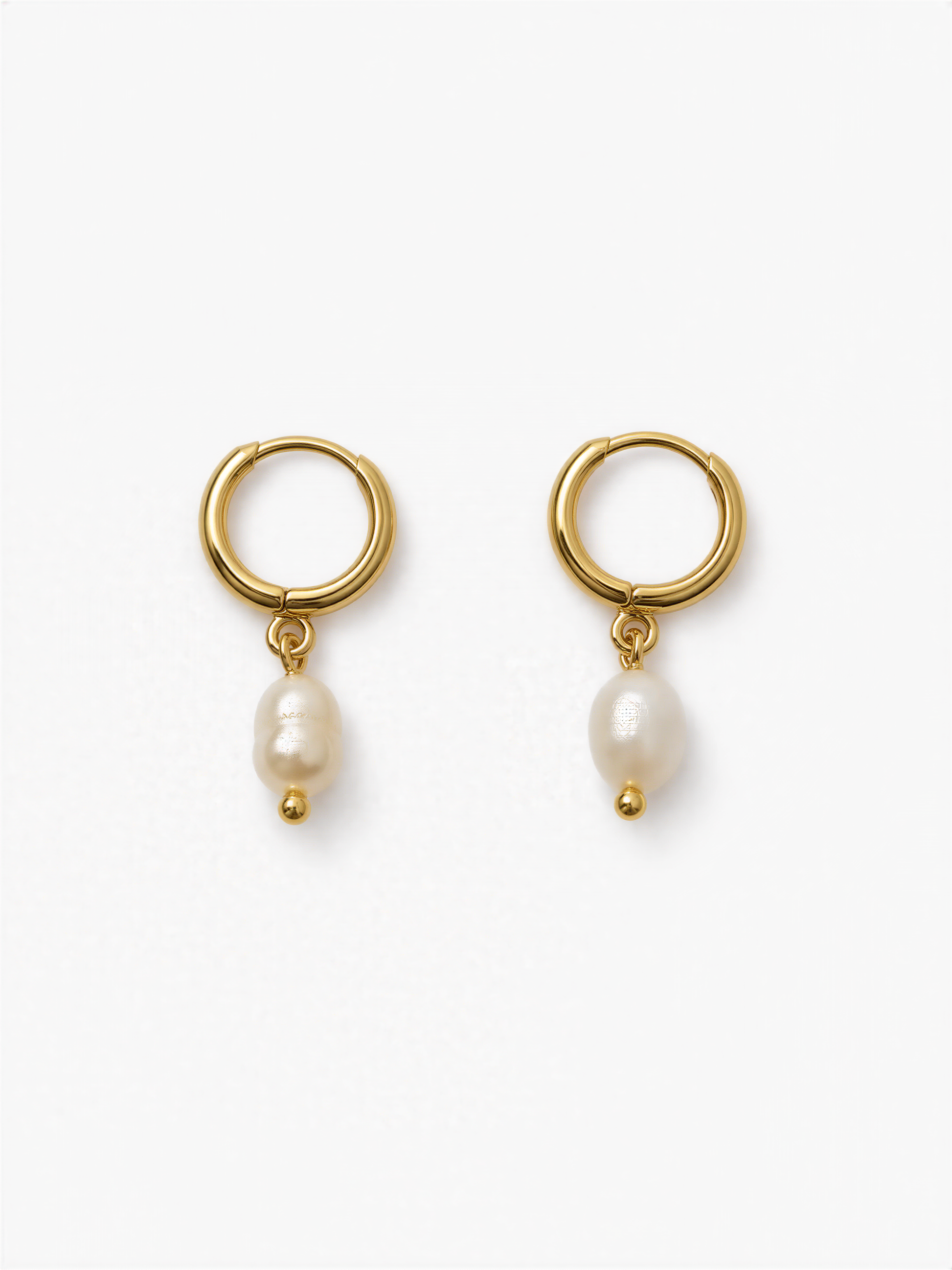 A pair of gold earrings with a pearl hanging from each earring.