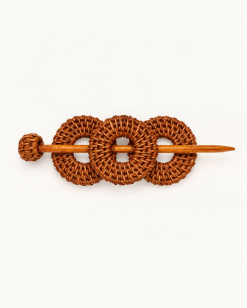 A wooden hair accessory with three woven circles, resembling a hair clip or bobby pin.