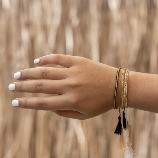 Golden Tassel Bracelets handmade by Village Thrive using natural materials.