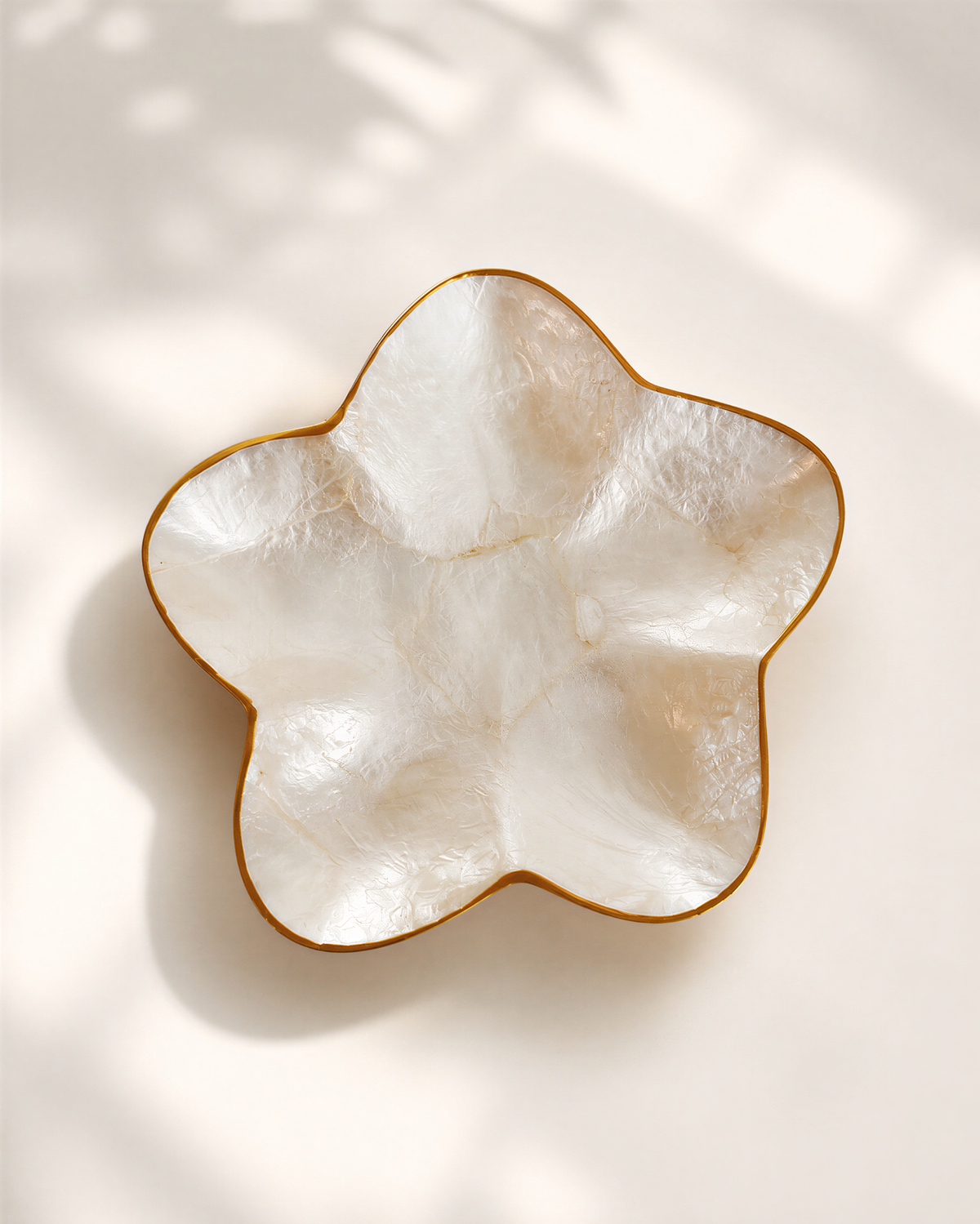 A white ceramic bowl with a gold rim, placed on a white background.