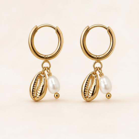 A pair of gold earrings with shells and pearls hanging from them.