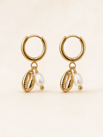 A pair of gold earrings with shells and pearls hanging from them.