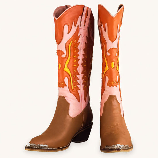 A pair of brown cowboy boots with orange and pink accents, featuring a flame-like design on the sides.