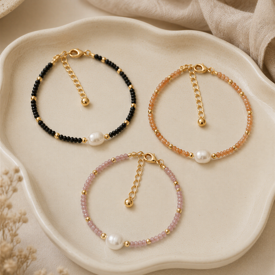 Three beaded bracelets with pearls are displayed on a white plate, arranged in a row.