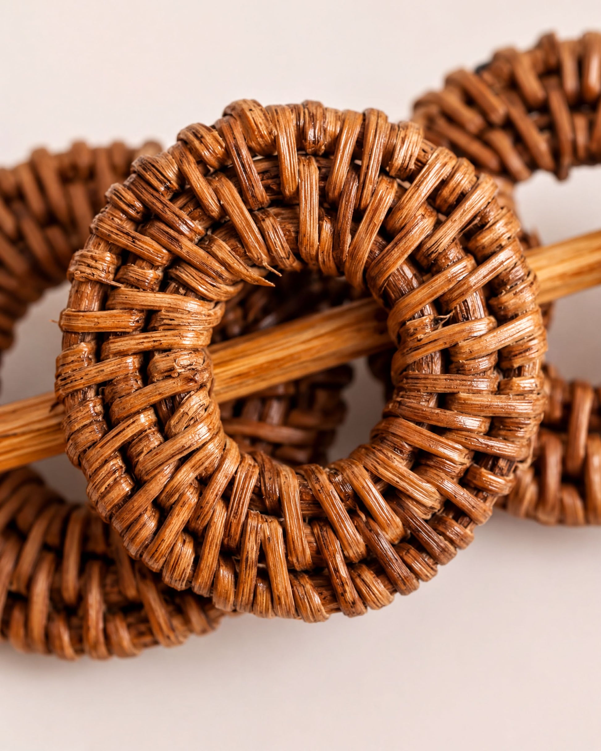 a close-up view of a woven object, possibly a piece of furniture or a decorative item, with a wooden stick or pole extending from it.