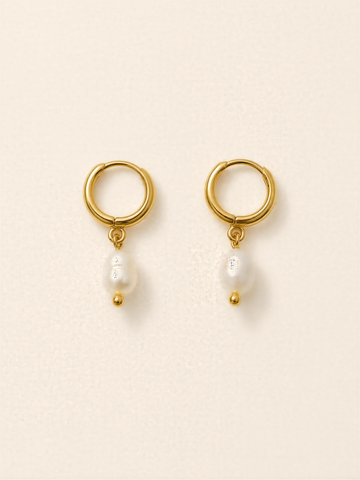 A pair of gold earrings with a pearl hanging from each earring.