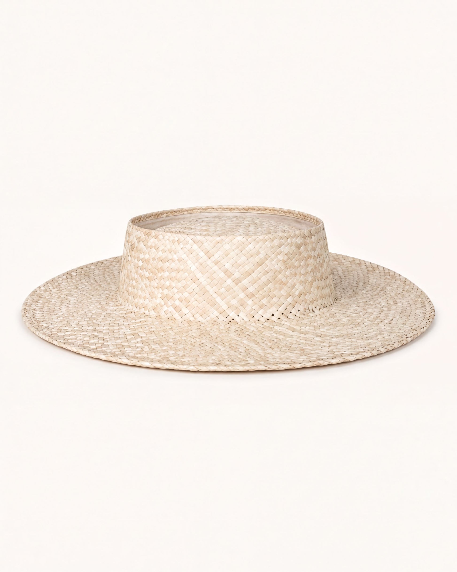 A straw hat with a wide brim and a round crown, sitting on a plain white background.