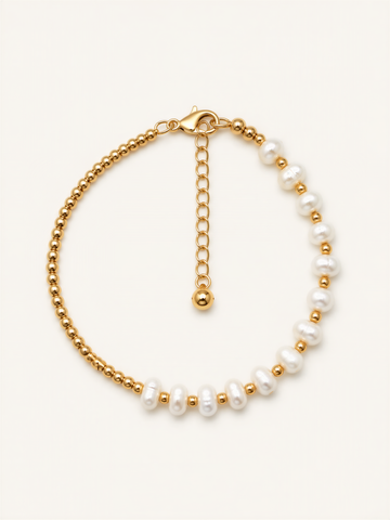 A gold-colored bracelet with a row of white pearls on one side and a clasp on the other side.