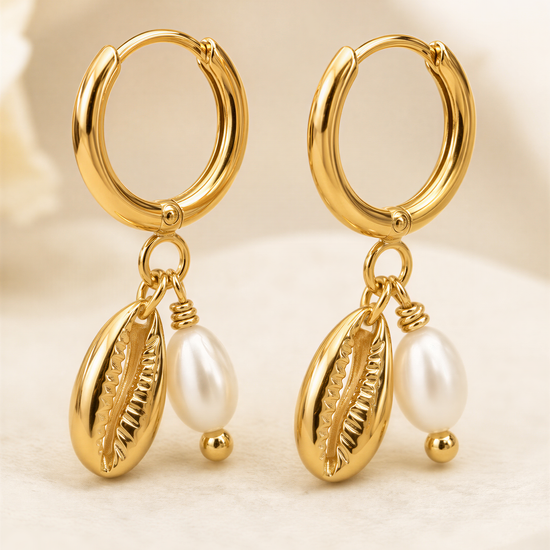 A pair of gold earrings with pearl accents and dangling charms.