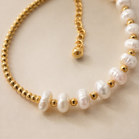 A gold-colored necklace with white pearls and gold beads.