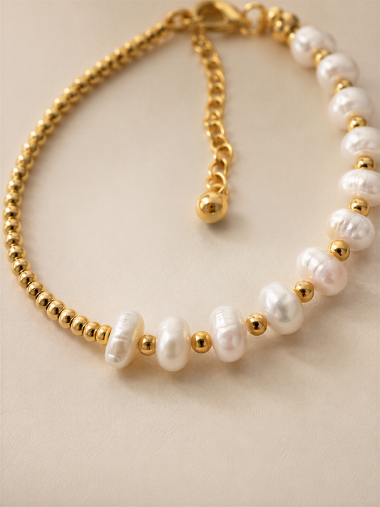 A gold-colored necklace with white pearls and gold beads.
