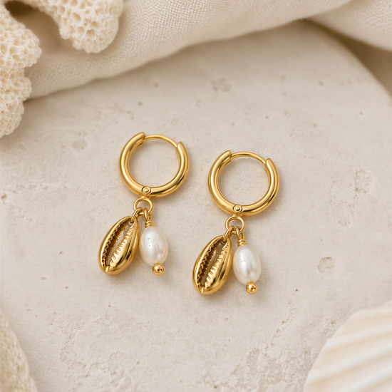 A pair of gold earrings with pearl accents and hoop earrings, resting on a white surface.