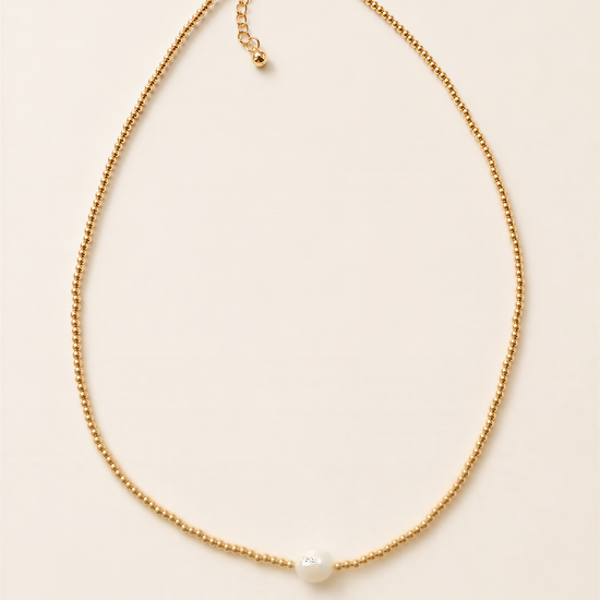 A delicate gold necklace with a single white pearl at the center.