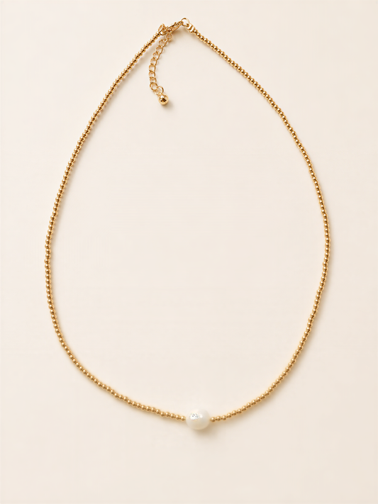A delicate gold necklace with a single white pearl at the center.