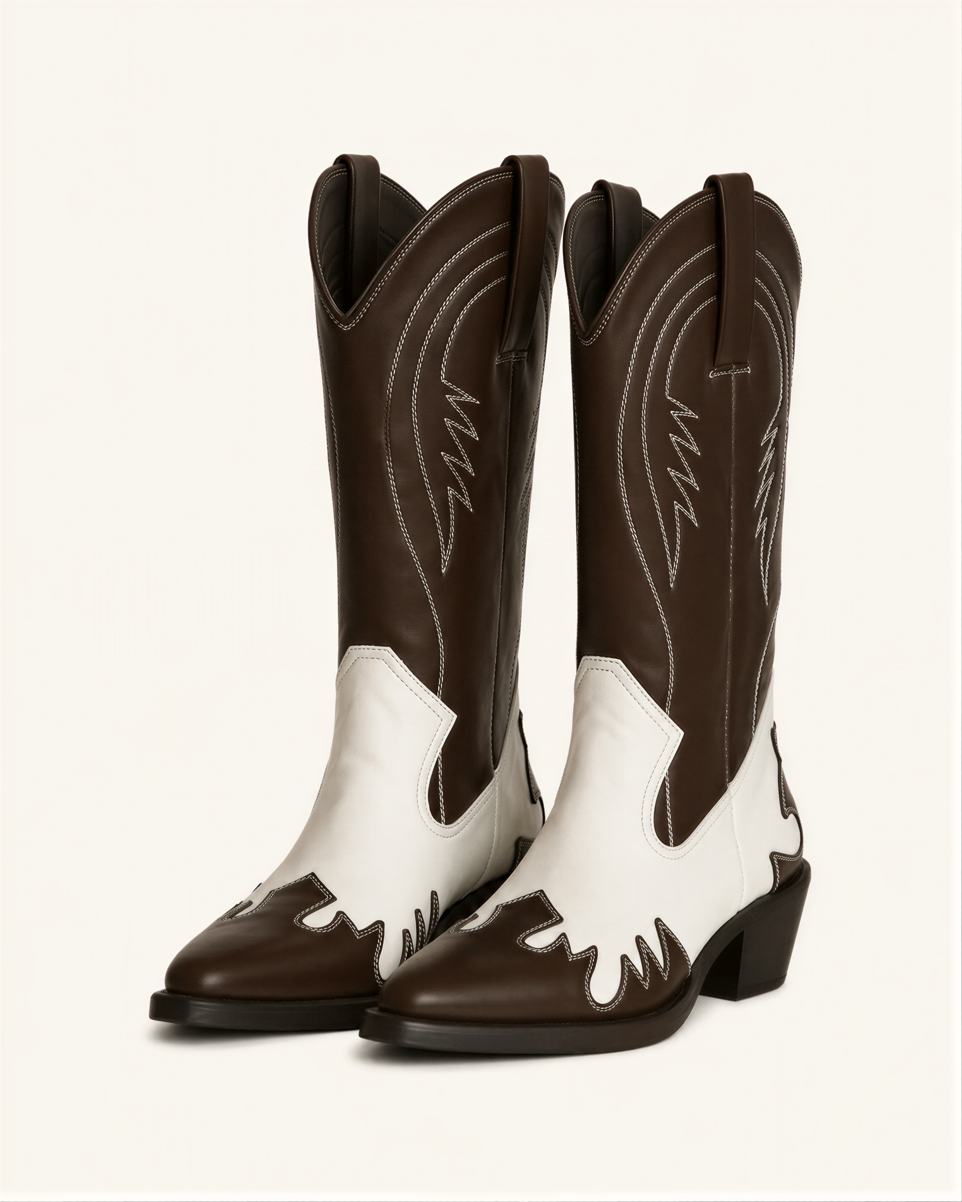 A pair of brown and white cowboy boots against a white background.