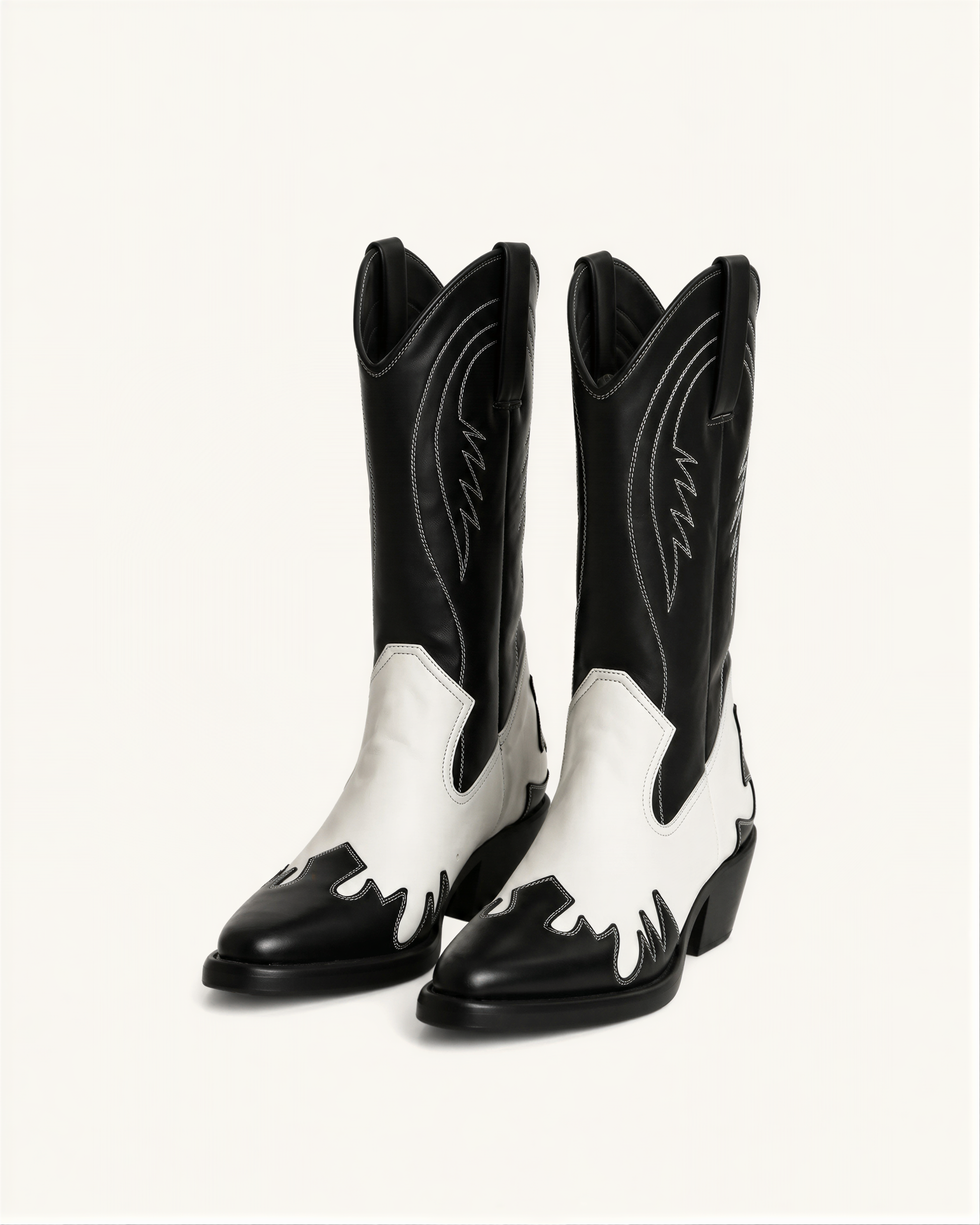 A pair of black and white cowboy boots against a white background.