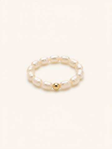 A bracelet made of white pearls and a single gold bead.