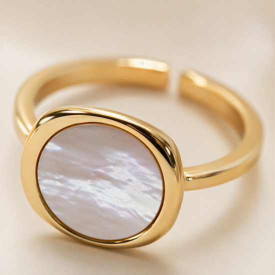 A gold ring with a large oval-shaped stone in the center.