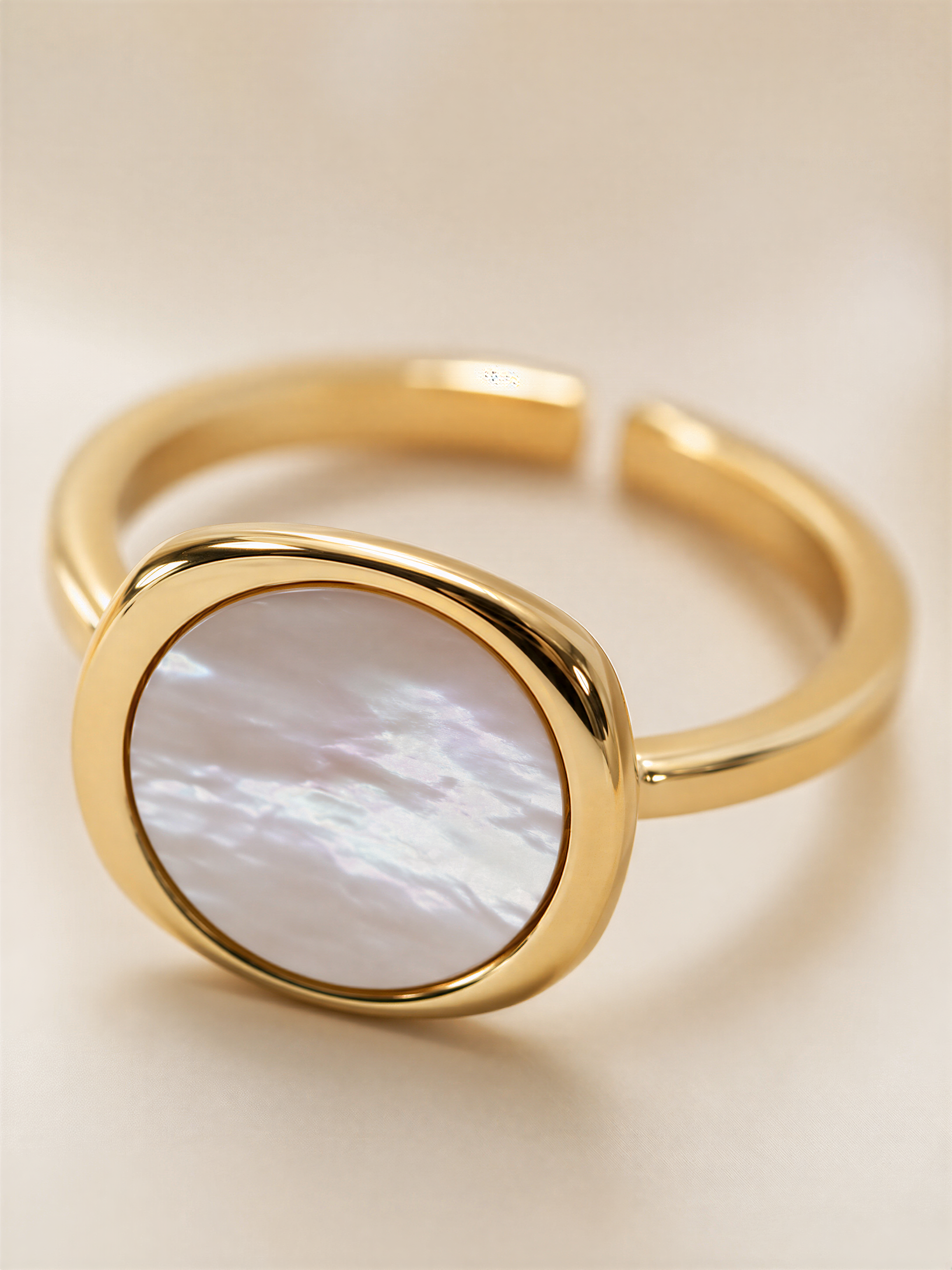 A gold ring with a large oval-shaped stone in the center.