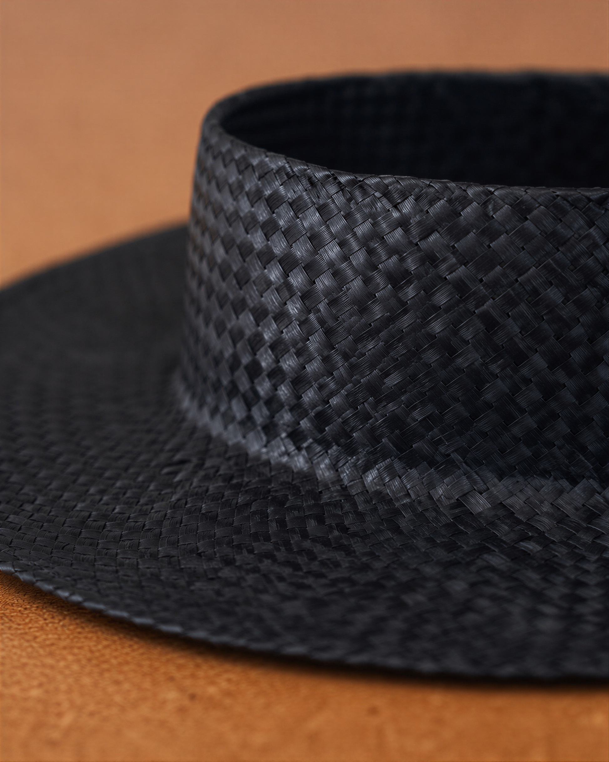 A close-up view of a black woven hat with a distinctive pattern.