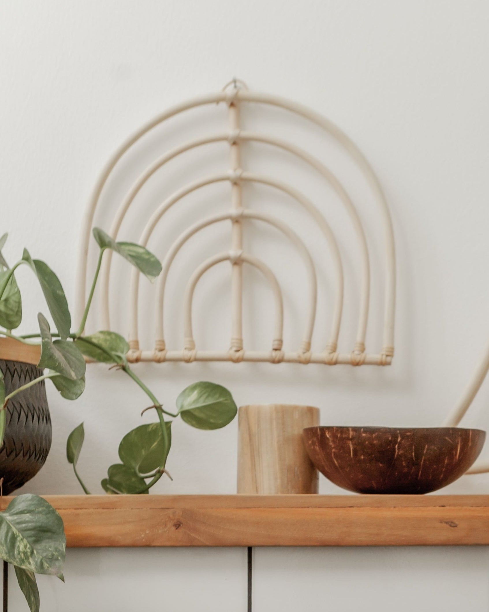 Rainbow Rattan Wall Decor handmade by Village Thrive using natural materials.