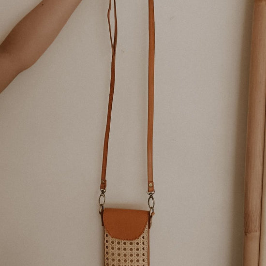 Nia Leather and Rattan Phone Sling handmade by Village Thrive using natural materials.
