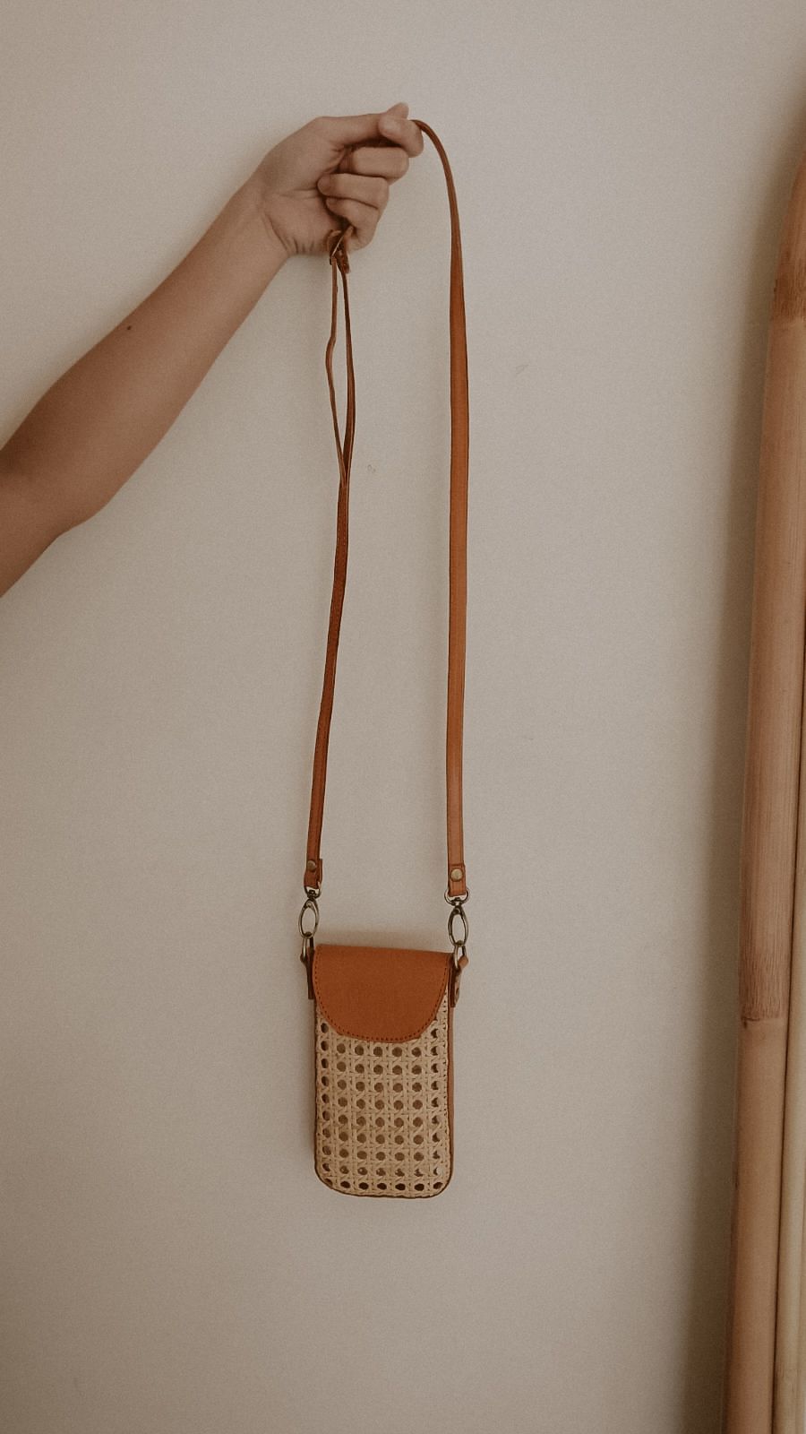 Nia Leather and Rattan Phone Sling handmade by Village Thrive using natural materials.