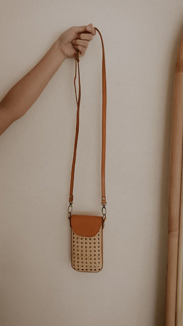 Nia Leather and Rattan Phone Sling handmade by Village Thrive using natural materials.