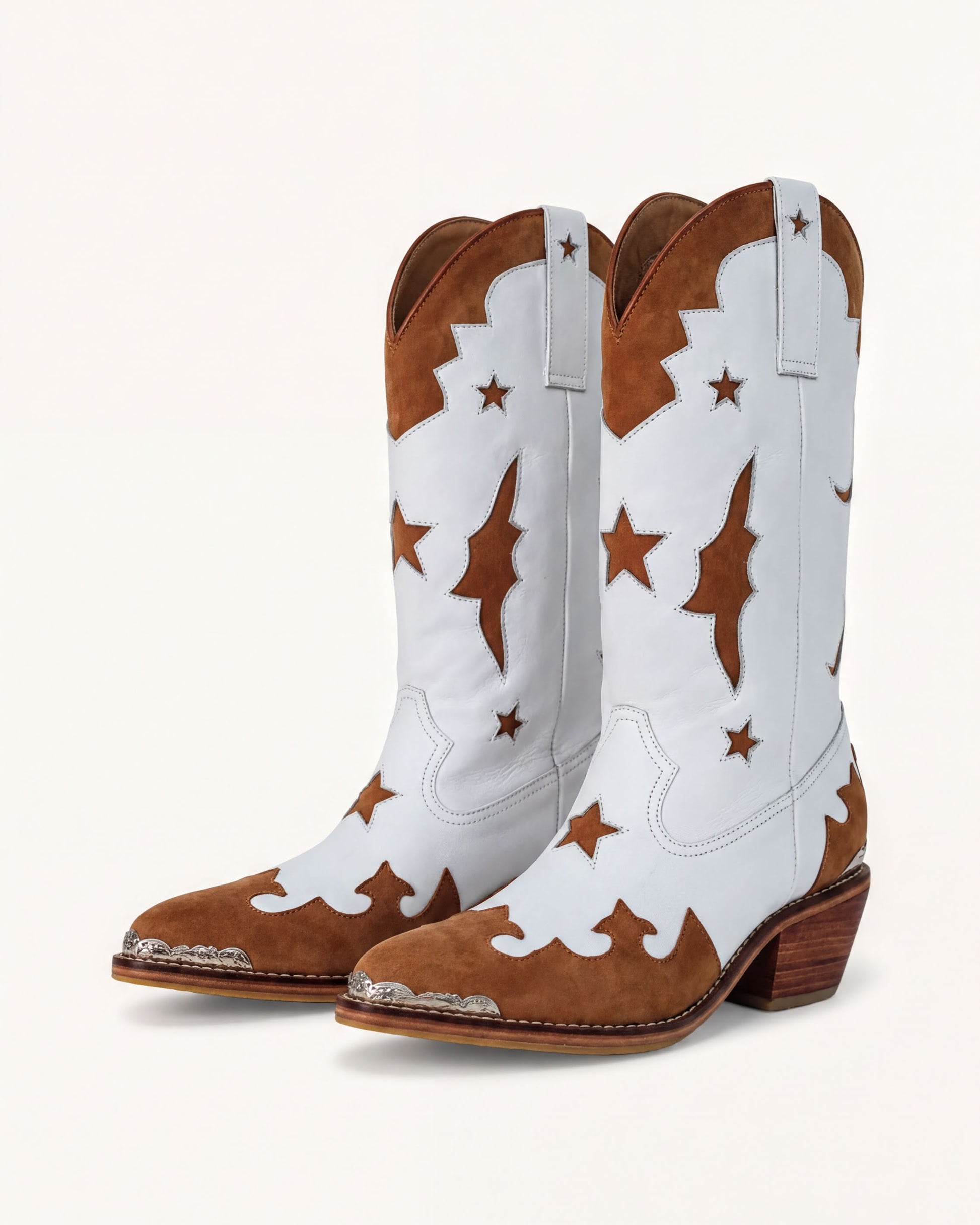 A pair of white cowboy boots with brown star patterns on the sides and heels.