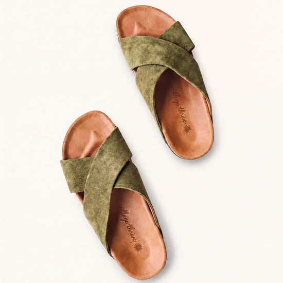 A pair of olive green sandals with a textured pattern and a strap across the top.