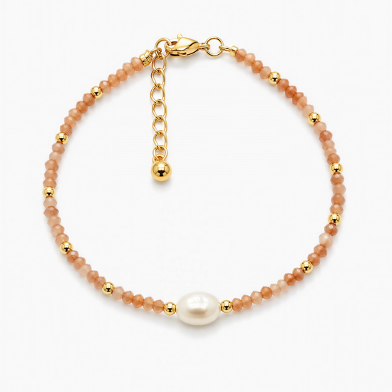 A gold-colored bracelet with a pearl bead and beaded beads in shades of orange and gold.