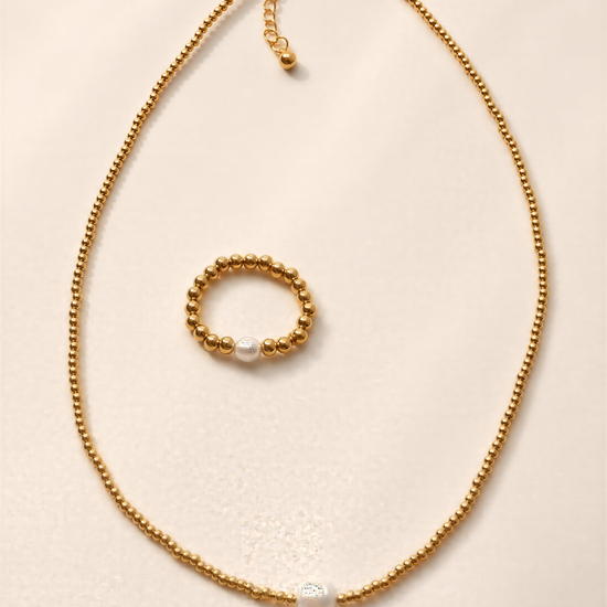 a gold necklace with a pearl pendant and a small gold bead bracelet.