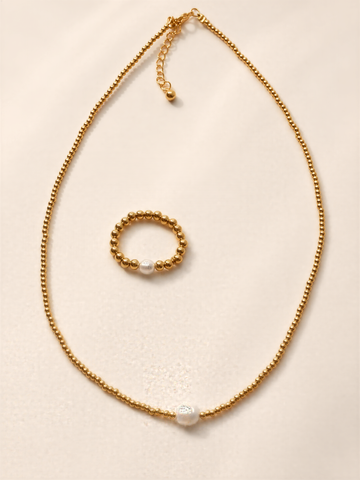 a gold necklace with a pearl pendant and a small gold bead bracelet.