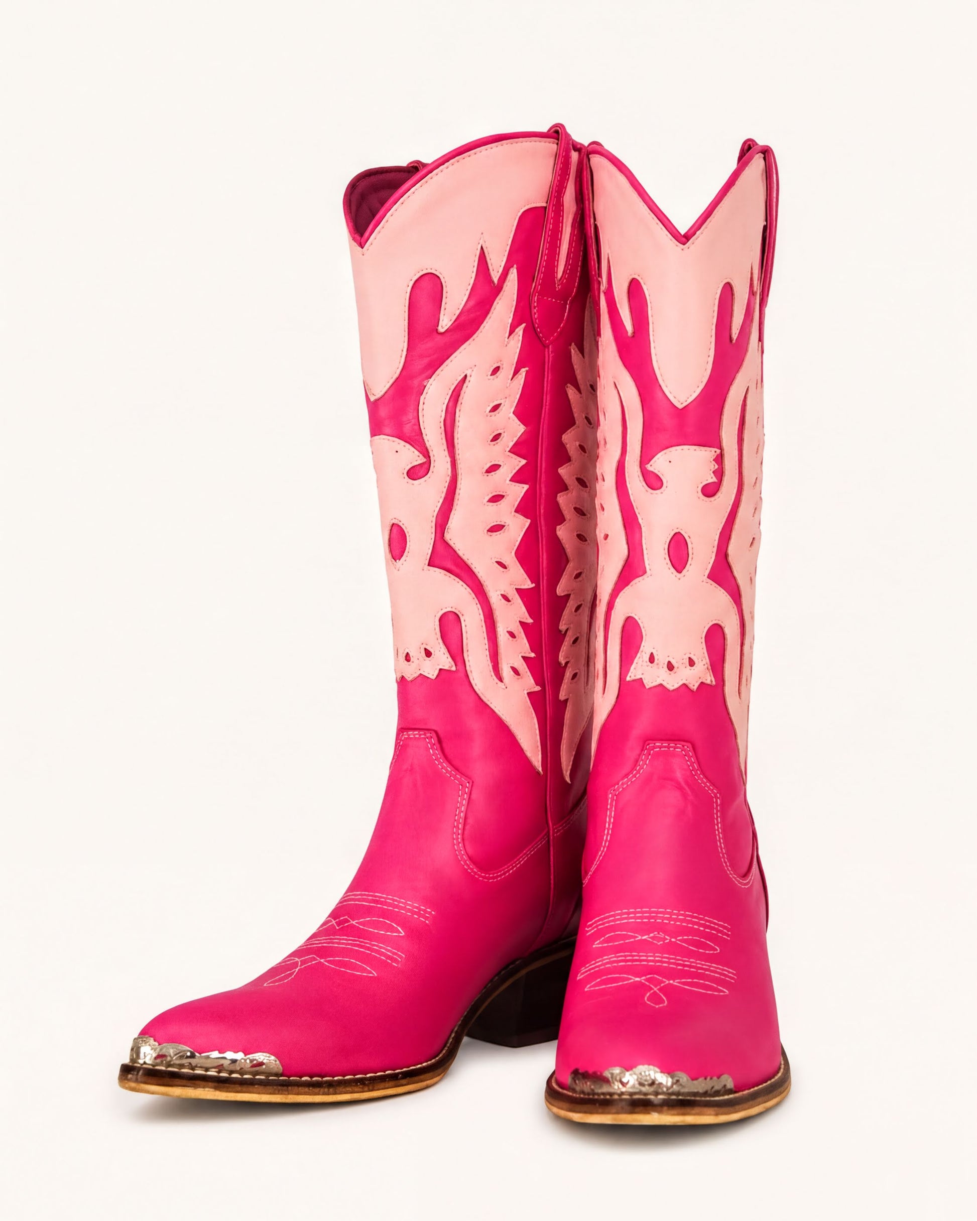 A pair of bright pink cowboy boots with a distinctive design on the sides.