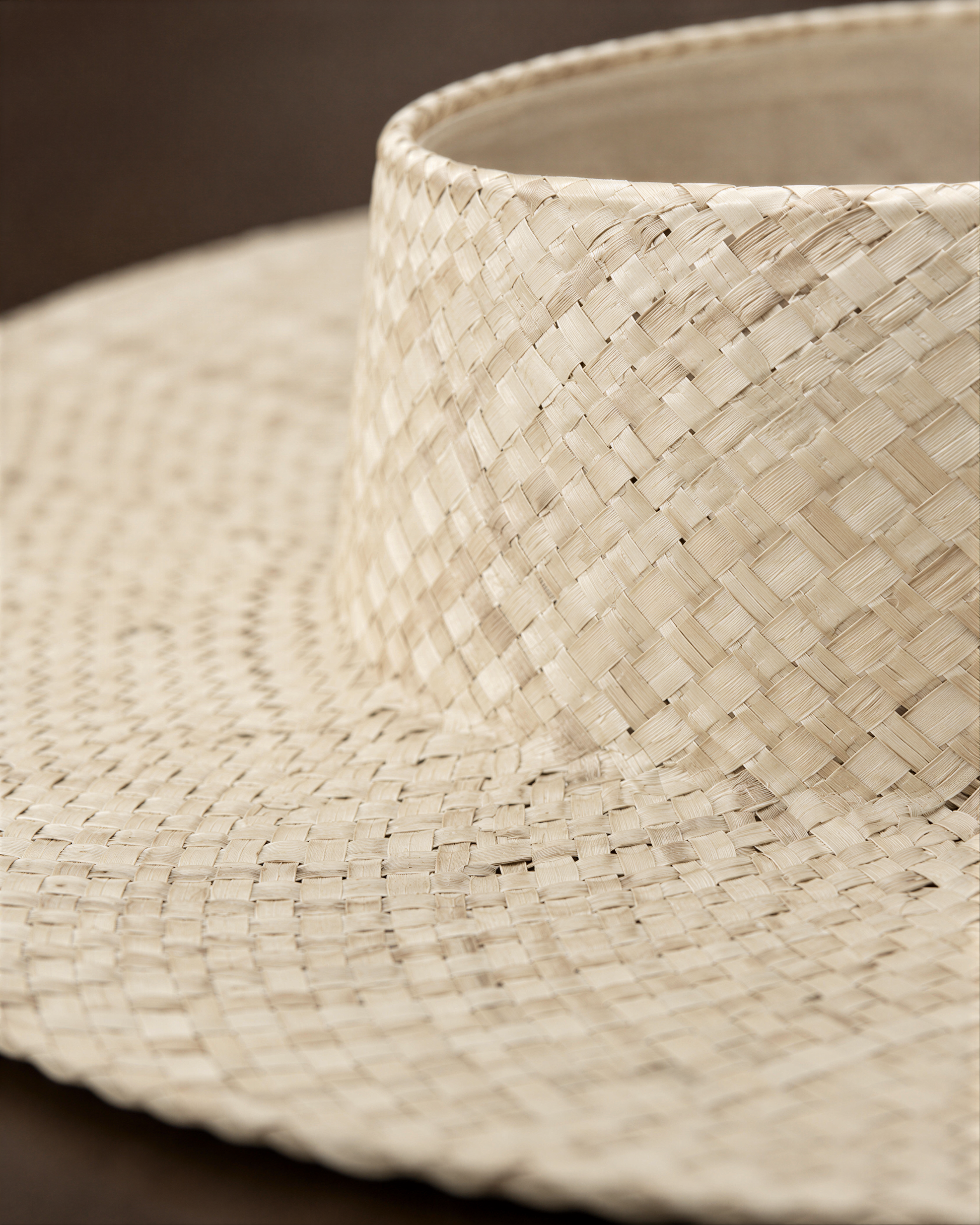 A close-up view of a woven straw hat, showcasing its intricate pattern and texture.