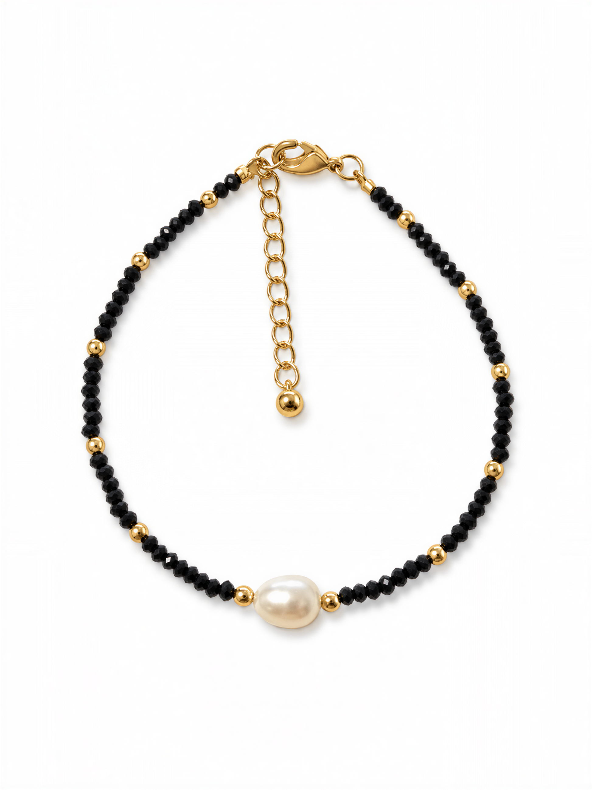 A gold-colored bracelet with black beads and a single white pearl bead.