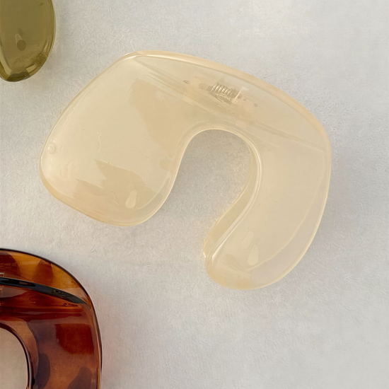 a close-up view of a clear plastic object, possibly a container or a piece of jewelry, with a brown and green color scheme.