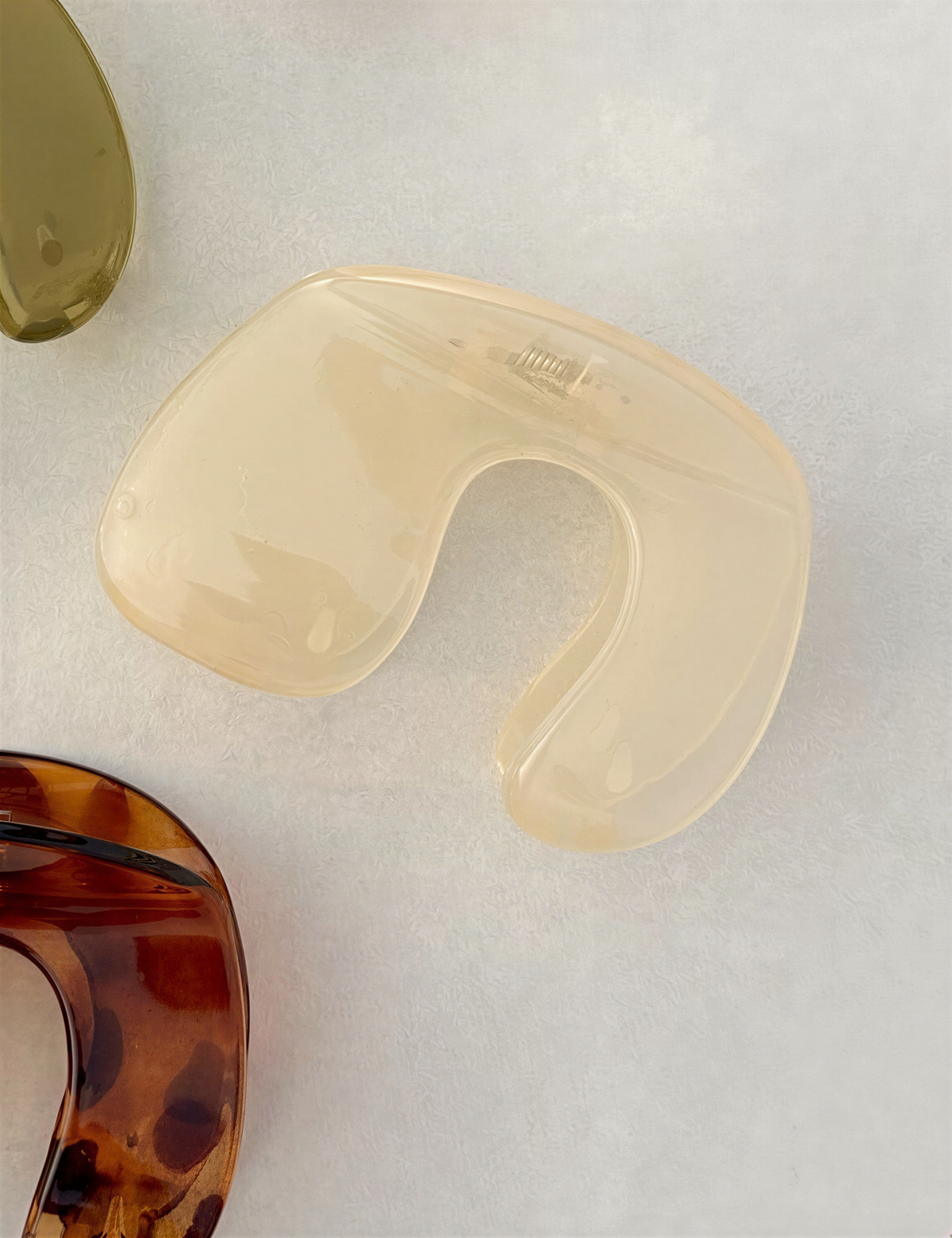 a close-up view of a clear plastic object, possibly a container or a piece of jewelry, with a brown and green color scheme.