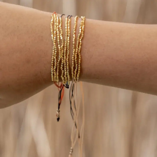 Terra Layered Bracelets in Gold handmade by Village Thrive using natural materials.