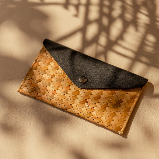 Cove Rattan & Leather Clutch handmade by Village Thrive using natural materials.