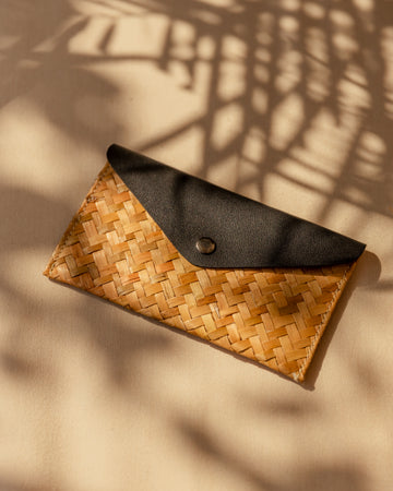 Cove Rattan & Leather Clutch handmade by Village Thrive using natural materials.