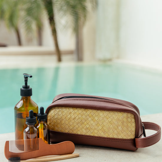 Cove Rattan & Leather Amenity Bag handmade by Village Thrive using natural materials.