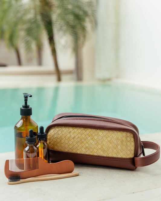 Cove Rattan & Leather Amenity Bag handmade by Village Thrive using natural materials.