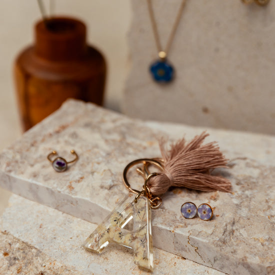 Wildflower Letter Keychain handmade by Village Thrive using natural materials.