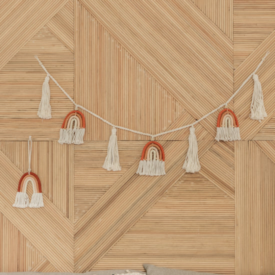 Rainbow Macrame Garland handmade by Village Thrive using natural materials.
